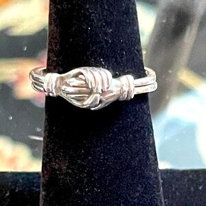Handmade sterling silver ring showing a handshake